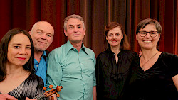 fünf Musiker stehen nebeneinander